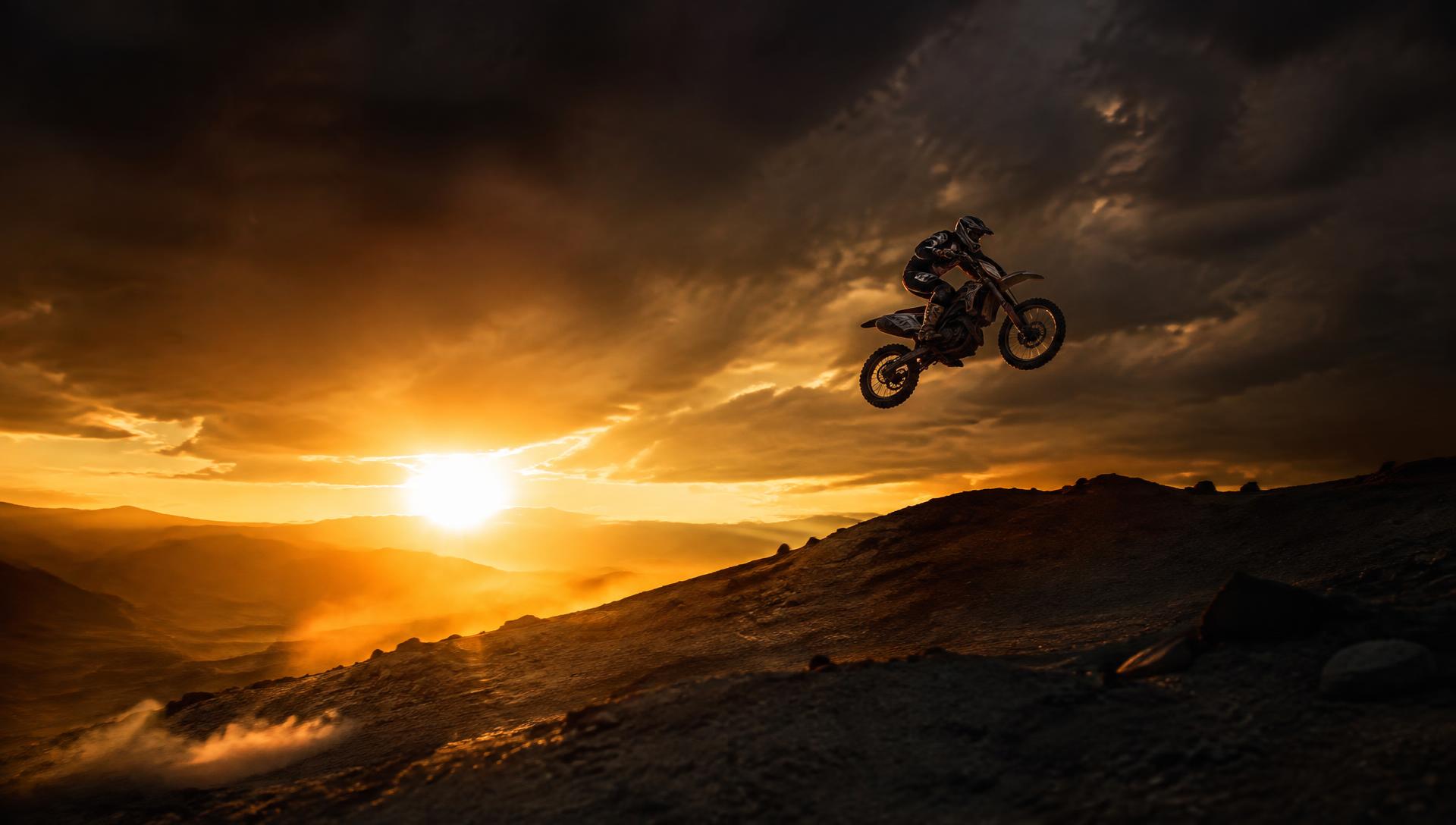 Motocross rider airborne at sunset